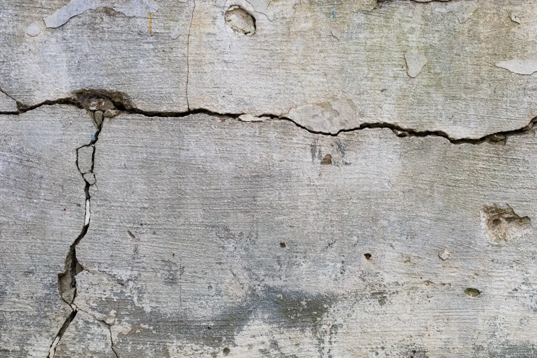 A close-up of a horizontal crack in a concrete foundation wall