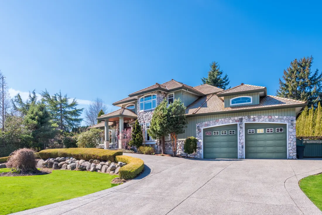 A large home exterior with a paved driveway